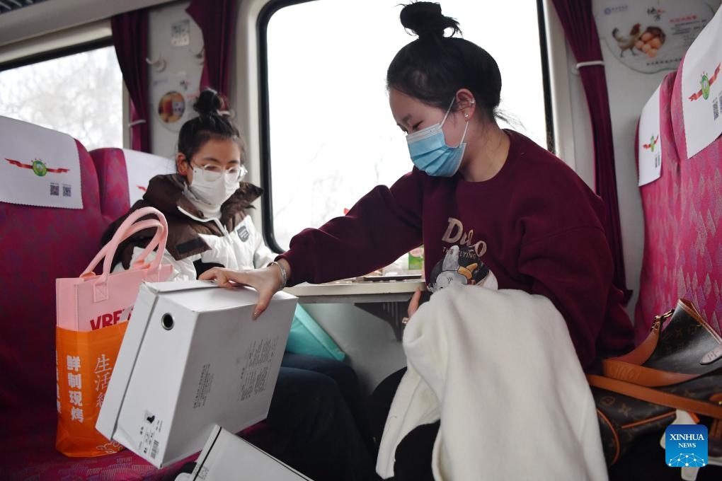 This photo taken on Feb. 4, 2024 shows passengers on their way home after shopping aboard the train No. 7503 in northwest China's Gansu Province. The pair of slow trains No. 7503 and No. 7504 run between Tianshui and Longxi in Gansu. Local residents are now taking them to travel between their towns and the urban areas to shop for goods in preparation of the upcoming Chinese Lunar New Year, or the Spring Festival.(Photo: Xinhua)