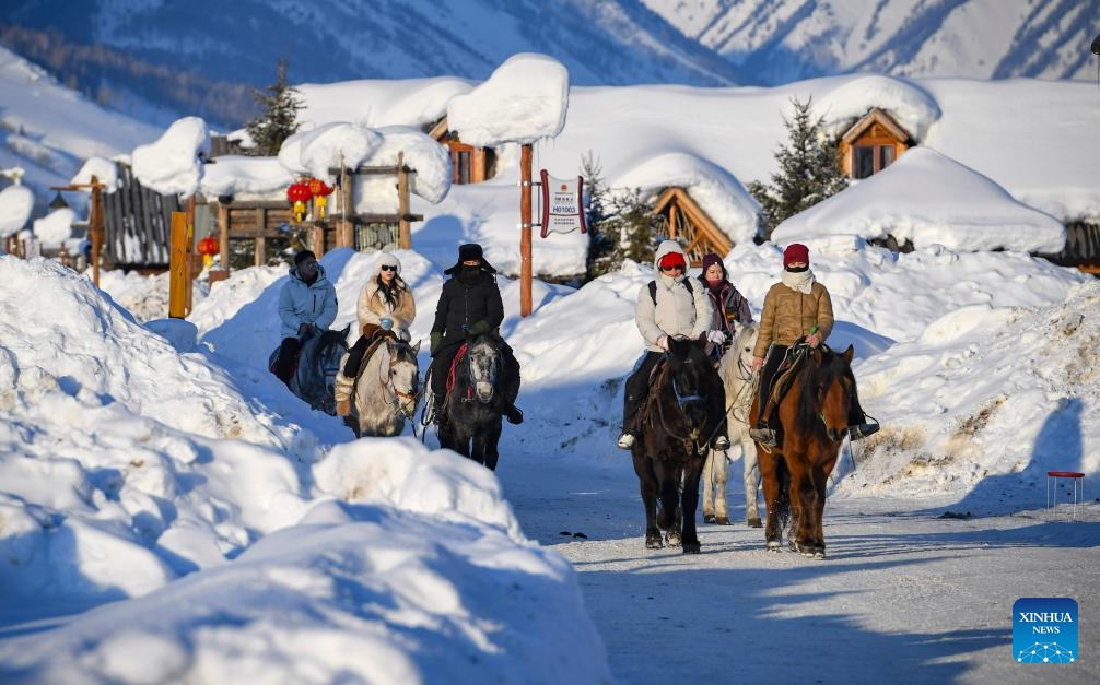 Tourists ride horses in Hemu Village in Altay Prefecture, northwest China's Xinjiang Uygur Autonomous Region, Feb. 5, 2024. Tucked away within Altay Prefecture, Hemu Village in Xinjiang offers the perfect winter getaway. As the Spring Festival is approaching, the village has become a hot spot for tourists.(Photo: Xinhua)