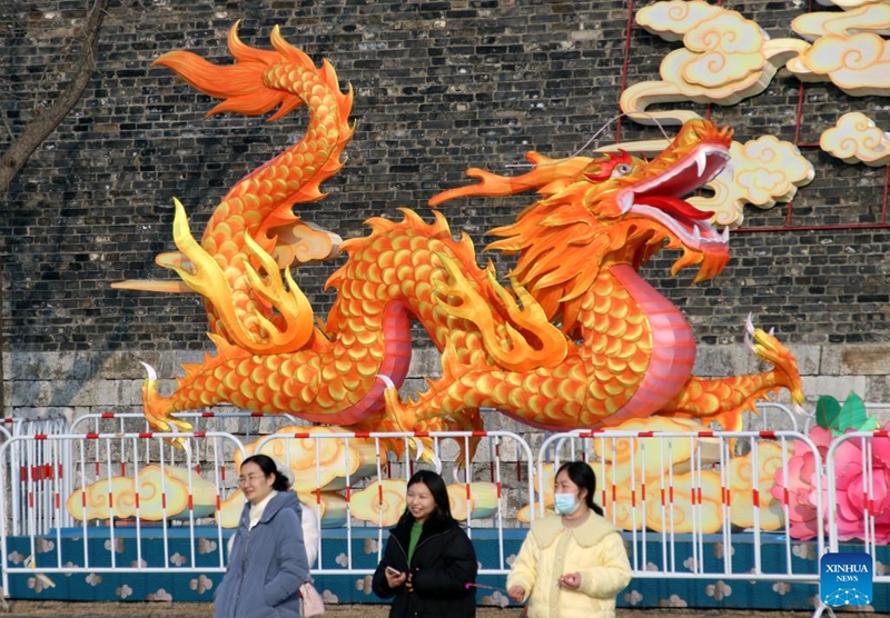 Tourists walk past a dragon-shaped light decoration in Suzhou, east China's Jiangsu Province, Feb. 9, 2024. People across the country held various celebrations on Friday, the Chinese Lunar New Year's eve, to welcome the traditional festival. Photo: Xinhua