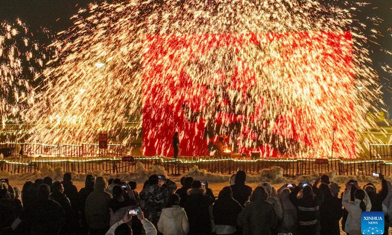 People watch a molten iron fireworks show in Zunhua, north China's Hebei Province, Feb. 10, 2024.Lighting and appreciating lanterns during the Spring Festival is a time-honored tradition in China. (Photo by Liu Mancang/Xinhua)