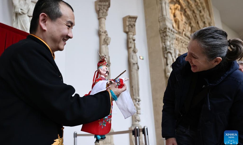 An artist of Zhangzhou Puppet Troupe from southeast China's Fujian Province shows the way of maneuvering a puppet to an audience at the City of Architecture and Heritage Museum in Paris, France, Feb. 10, 2024. (Xinhua/Gao Jing)