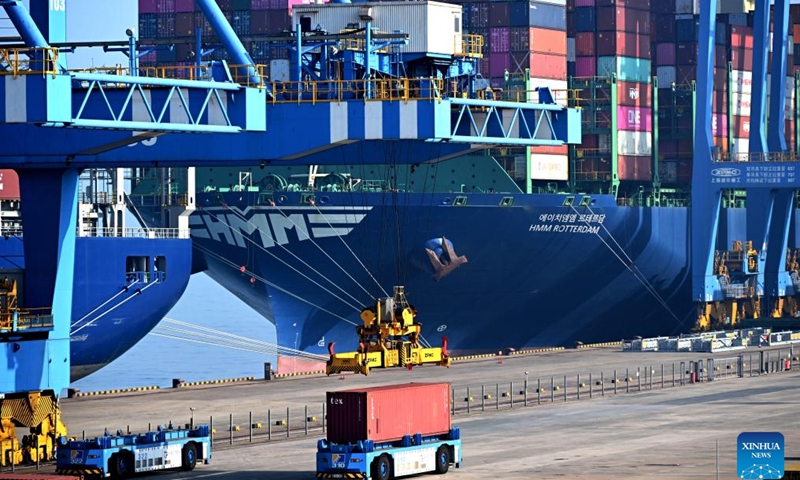 Unmanned trucks transport containers at Qingdao Port, east China's Shandong Province, Feb. 11, 2024. The Qingdao port is busy handling goods for export during the Spring Festival holiday. (Xinhua/Li Ziheng)