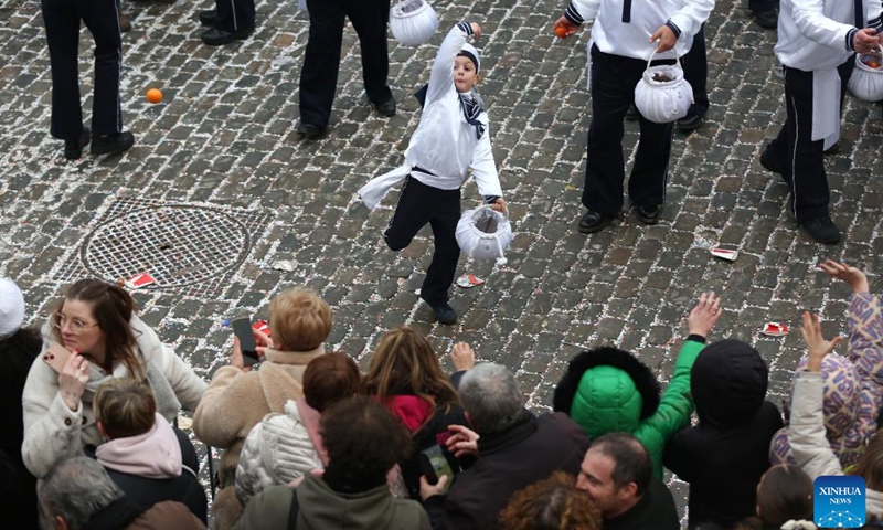 A boy wearing costume of Sailor throws an orange symbolizing good luck to visitors during the parade of Shrove Tuesday, the last day of Carnival, in Binche, Belgium, Feb. 13, 2024. Binche's three-day carnival, a UNESCO World Heritage event and one of the most famous carnivals in Europe, reached its climax on Tuesday. (Photo: Xinhua)