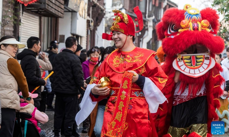 A staff member in the costume of the God of Wealth interacts with tourists in Jinhua, east China's Zhejiang Province, Feb. 14, 2024. (Photo: Xinhua)