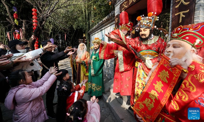 Staff members in the costume of the God of Wealth interact with tourists in Zhuquan Village of Linyi City, east China's Shandong Province, Feb. 14, 2024. (Photo: Xinhua)