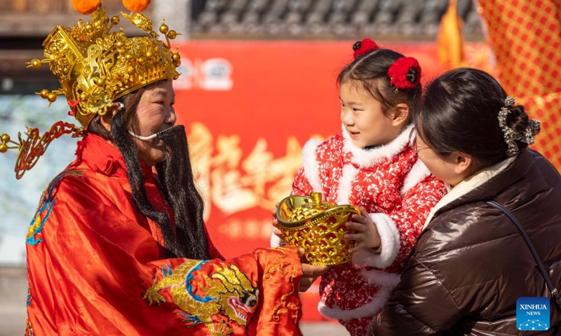 A staff member in the costume of the God of Wealth interacts with tourists in Taizhou, east China's Jiangsu Province, Feb. 14, 2024. (Photo: Xinhua)