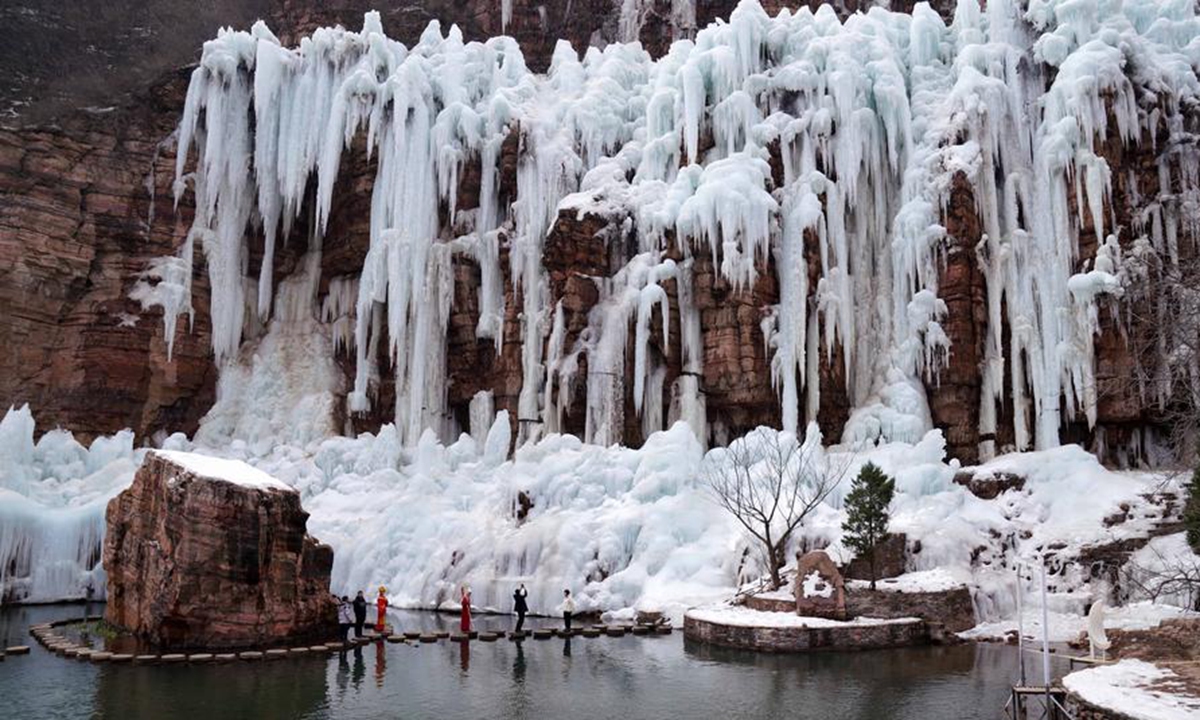 Tourists enjoy the frozen waterfall scenery at the Tianhe Mountain scenic spot in Xingtai, north China's Hebei Province, Feb. 14, 2024. (Photo by Chen Lei/Xinhua)