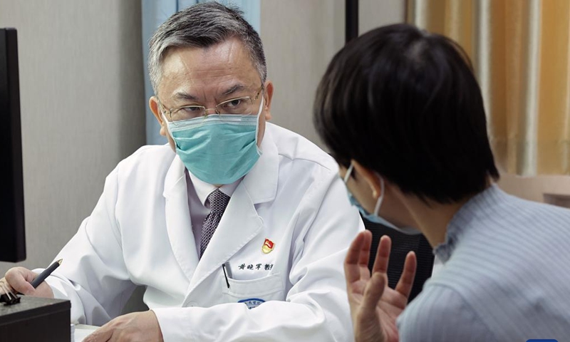 Huang Xiaojun speaks with a patient at Peking University People's Hospital in Beijing, capital of China, July 6, 2023. (Xinhua/Zhang Yuwei)