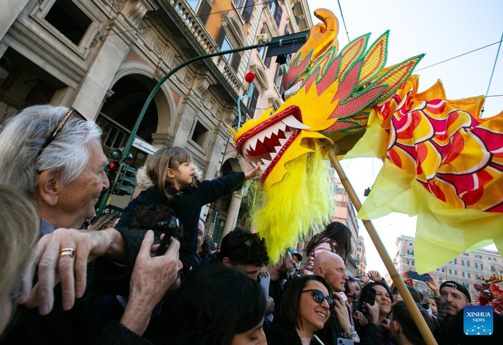 A girl interacts with a dragon dance prop during a parade celebrating the Chinese New Year in Rome, Italy, Feb. 18, 2024.(Photo: Xinhua)