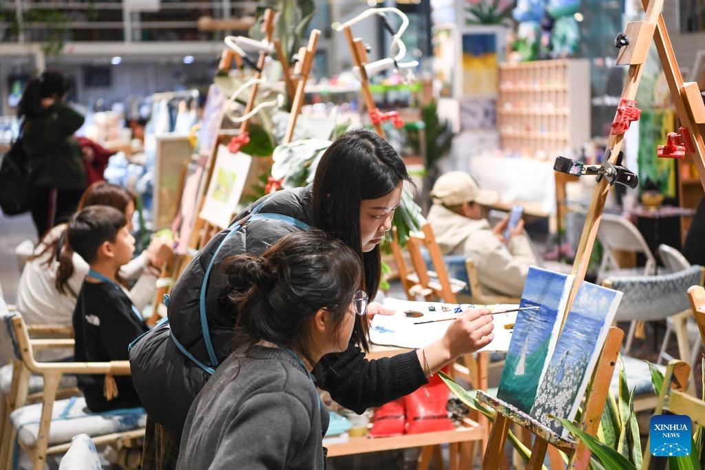 People enjoy painting at the Beicang Cultural and Creative Block in Jiangbei District of southwest China's Chongqing Municipality, Feb. 15, 2024. In recent years, various urban renewal measures have been taken in Chongqing to transform old streets, old factories, old buildings into tourism attractions, the gathering place for emerging industries etc.(Photo: Xinhua)