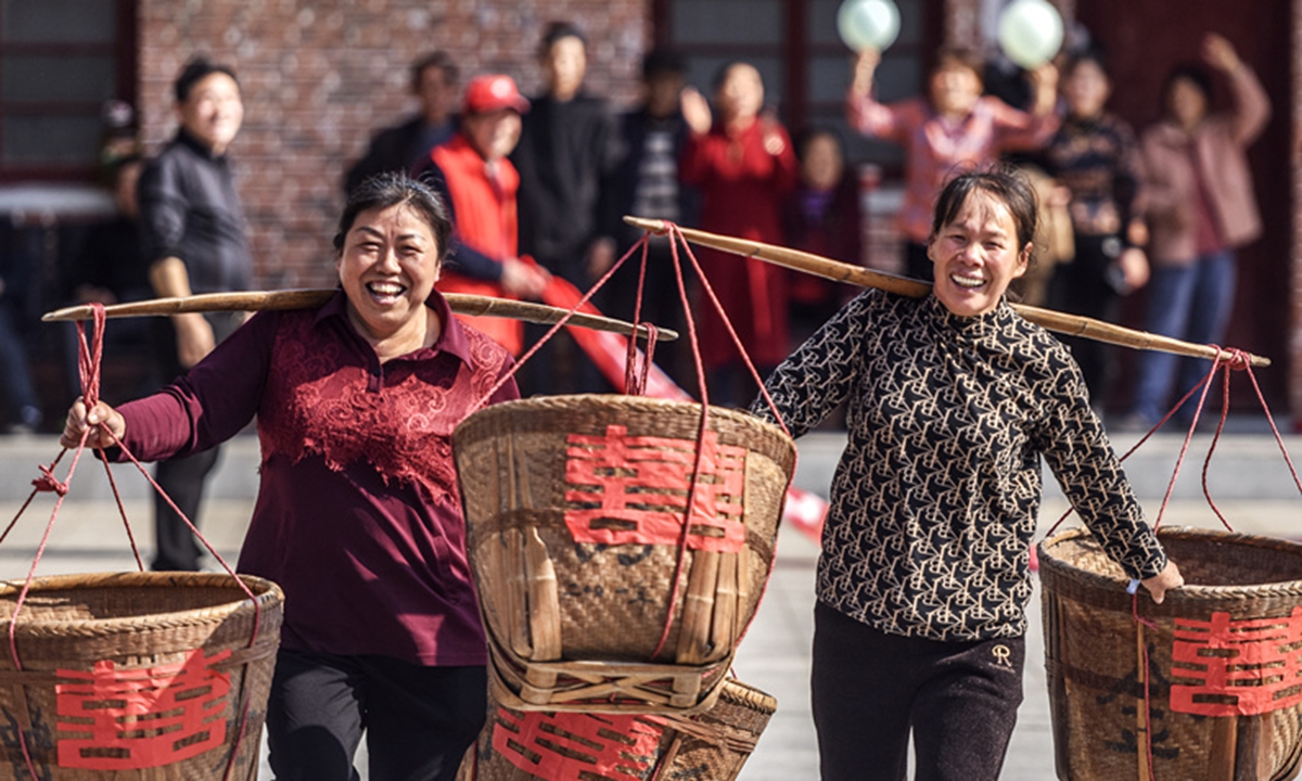 Farmers carry baskets as they participate in a “grabbing food” competition in Gaotian village in Fuzhou, East China's Jiangxi Province, on February 19, 2024. During the Spring Festival, the village turned some activities that often occur during farming and life into fun sports competitions, meeting the fitness needs of villagers at their doorstep. Photo: VCG