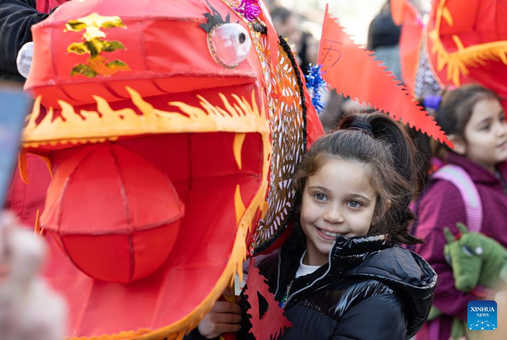 A girl poses for a photo with a lantern during a parade celebrating the Chinese New Year in Rome, Italy, Feb. 18, 2024.(Photo: Xinhua)