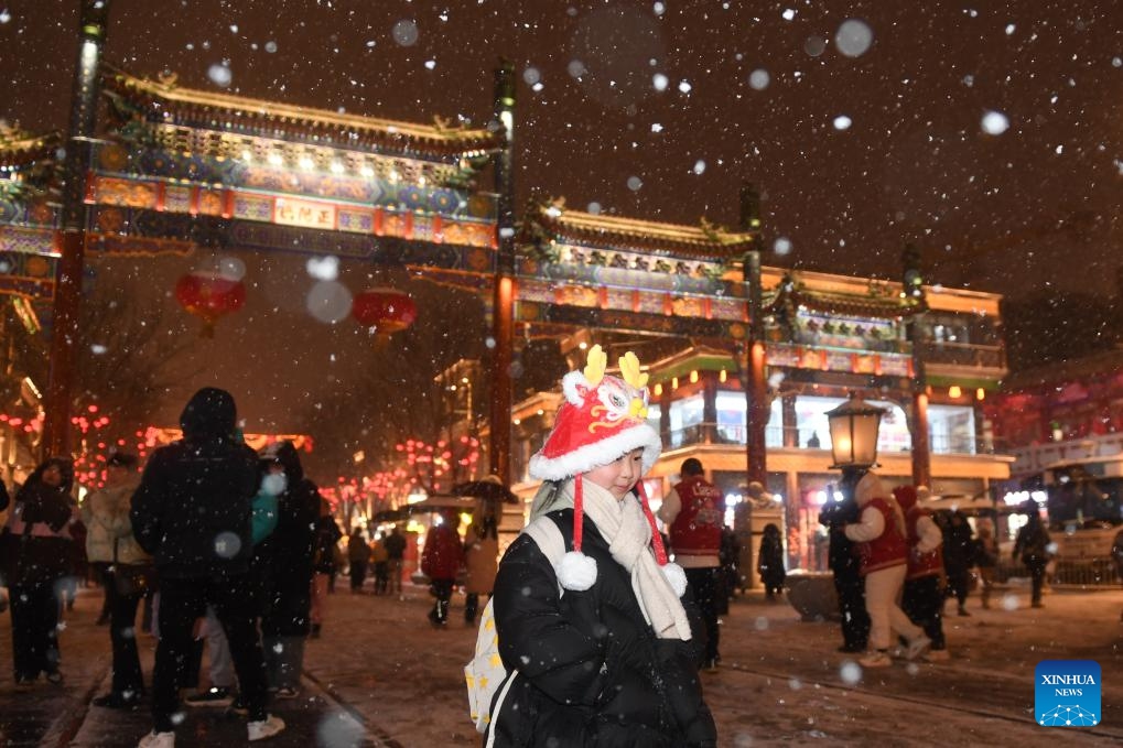 A child walks in the snow at Qianmen Street in Beijing, capital of China, Feb. 20, 2024. Beijing saw a snowfall on Tuesday.(Photo: Xinhua)