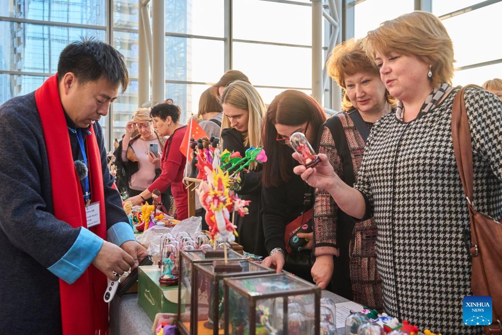 Visitors look at dough sculptures at an exhibition featuring intangible cultural heritages of China's Liaoning Province in Vladivostok, Russia, Feb. 20, 2024. An exhibition featuring intangible cultural heritages of China's Liaoning Province kicked off here on Tuesday. Chinese craftsmen demonstrated here their skills in making sugar figures, dough sculptures, finger paintings, amber carvings, and so on. The exhibition, attracting lots of visitors, will last till Feb. 25.(Photo: Xinhua)