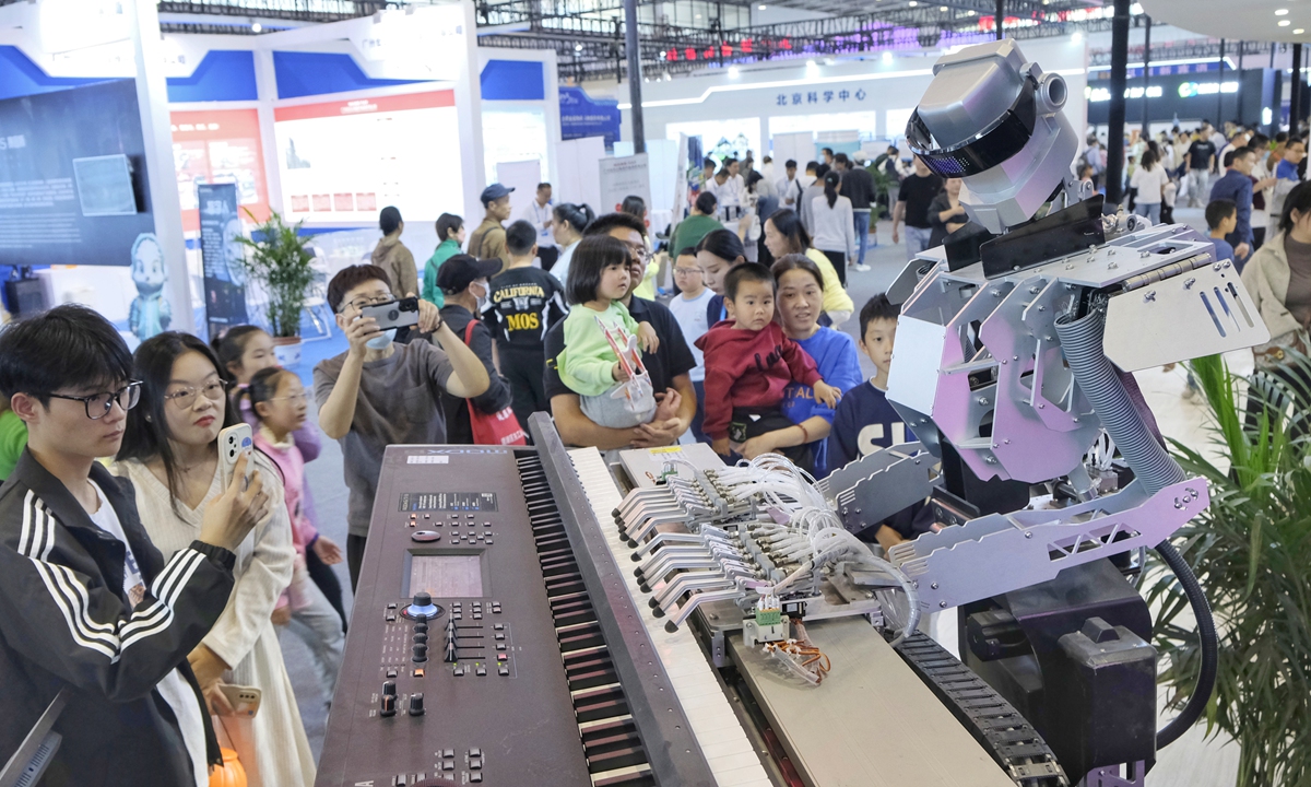 Visitors watch a robot playing the piano at the 11th China (Wuhu) Popularized Science Products Exposition held in East China's Wuhu, on October 22, 2023. Photo: VCG
