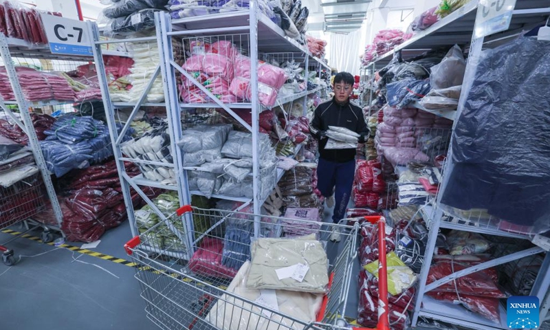 A staff member sorts children's garment in a warehouse in Zhili Town of Huzhou City in east China's Zhejiang Province, Feb. 27, 2024. Zhili, located in the Yangtze River Delta economic circle, is renowned for its children's garment industry, whose complete industrial chain covers design, production, sales, storage, and logistics.(Photo: Xinhua)