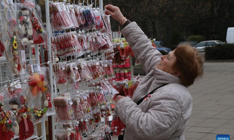 A stall owner arranges Martenitsi for sales in Sofia, Bulgaria, March 1, 2024. Bulgarian people marked the day named Baba Marta on Friday. On that day and a few days afterwards, Bulgarians exchange and wear the so-called Martenitsa - a small piece of adornment, made of white and red yarn. (Photo: Xinhua)