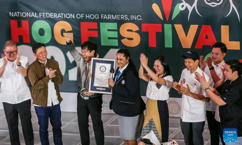 Guinness World Record official adjudicator Sonia Ushirogochi (C) presents a certificate for the new Guinness World Record during the National Hog Festival in Quezon City, the Philippines, on March 1, 2024. Hog farmers in Quezon City set the Guinness World Record for the most varieties of pork dishes on display during the launch of the five-day National Hog Festival on Friday. (Photo: Xinhua)