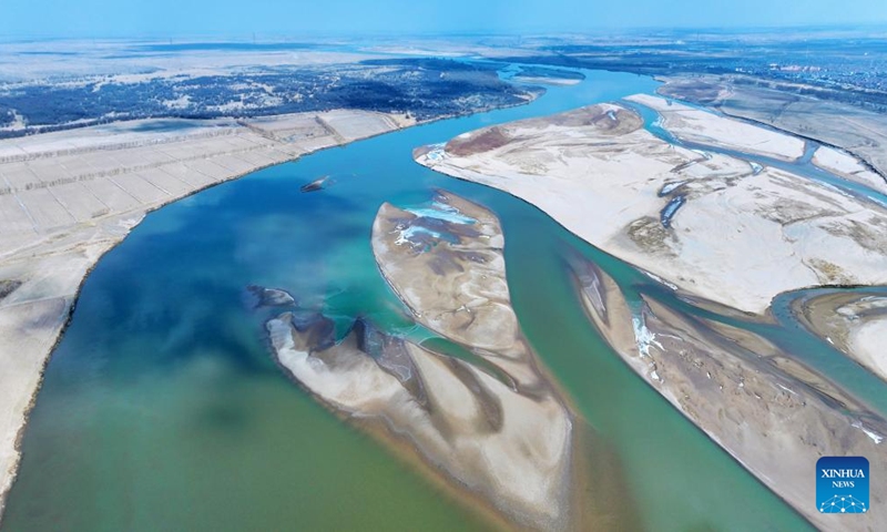 An aerial drone photo taken on March 1, 2024 shows the scenery at a section of the Yellow River in northwest China's Ningxia Hui Autonomous Region. With the temperature rising, the ice in Ningxia section of the Yellow River has been gradually melting. Flocks of migratory birds fly over the tidal-flat area and the turquoise water, adding a touch of vitality to the spring scenery. (Photo: Xinhua)