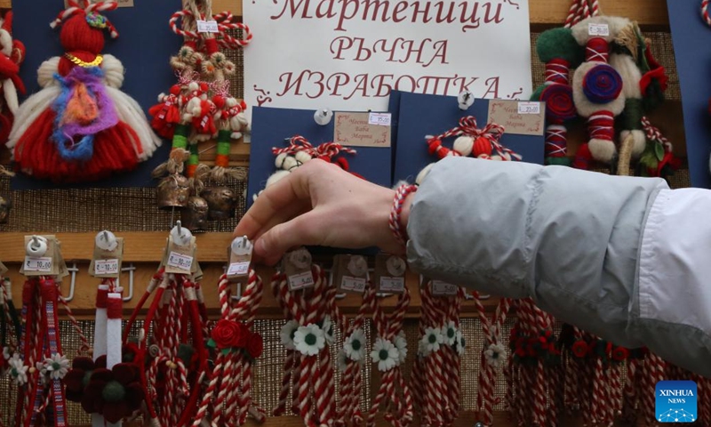 A stall owner arranges Martenitsi for sales in Sofia, Bulgaria, March 1, 2024. Bulgarian people marked the day named Baba Marta on Friday. On that day and a few days afterwards, Bulgarians exchange and wear the so-called Martenitsa - a small piece of adornment, made of white and red yarn. (Photo: Xinhua)