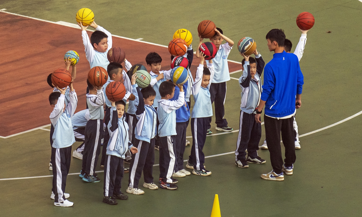 Children who have just returned from winter vacation play basketball at a primary school in Haikou, South China's Hainan Province, on March 4, 2024. Photo: VCG