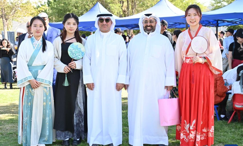 Kuwaiti people pose for a group photo with women wearing traditional Chinese attire during the Chinese Culture and Food Festival at the Sheikh Jaber Al-Ahmad Cultural Centre in the Capital Governorate, Kuwait, on March 9, 2024. The Chinese Culture and Food Festival was held here on Saturday. (Photo by Asad/Xinhua)