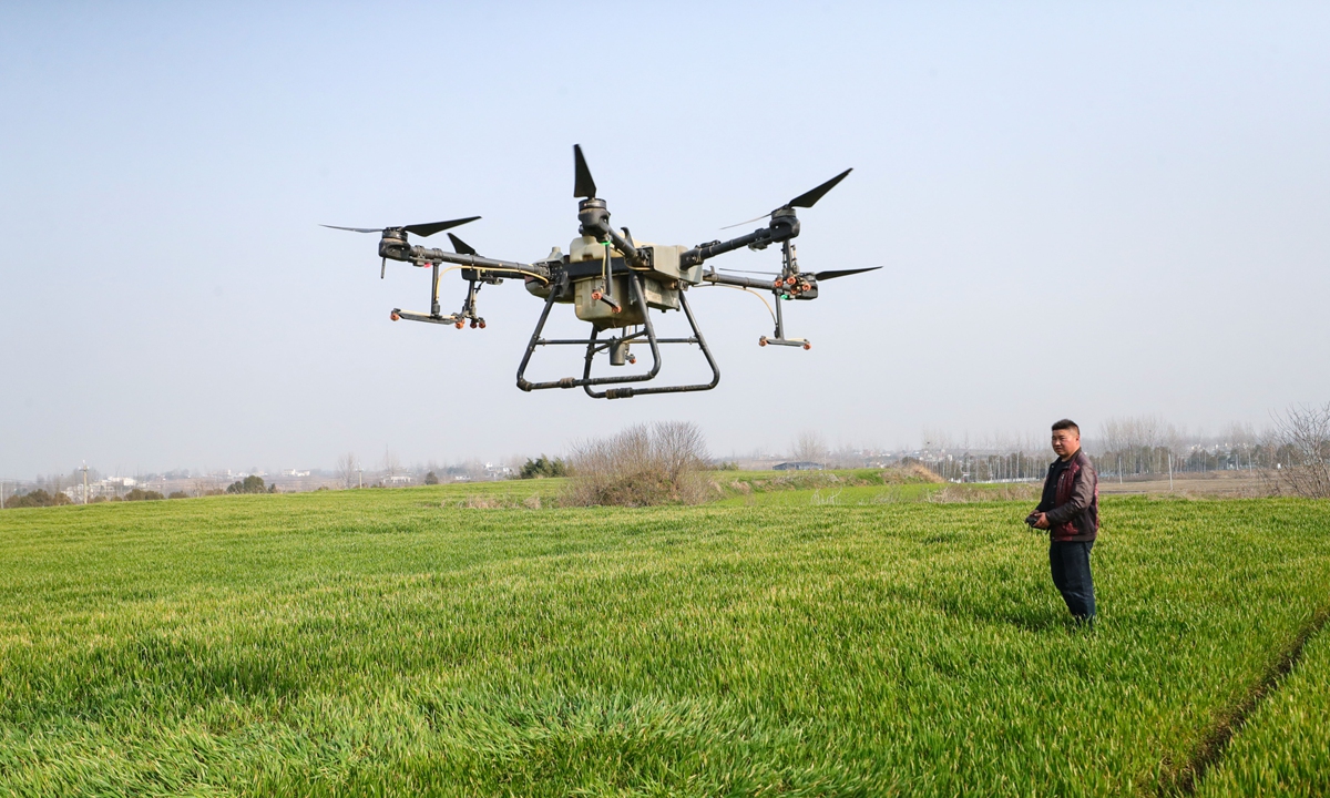 A technician operates a drone to spray fertilizer on crops at a wheat field in Central China's Henan Province on March 12, 2024. As of end-2023, China's drone industry had realized output of 152 billion yuan ($21.18 billion), with an annual growth rate of 27.5 percent. Photo: VCG