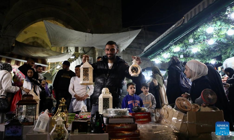 A man holds lanterns at a market during Ramadan in Jerusalem's Old City, on March 12, 2024.(Photo: Xinhua)