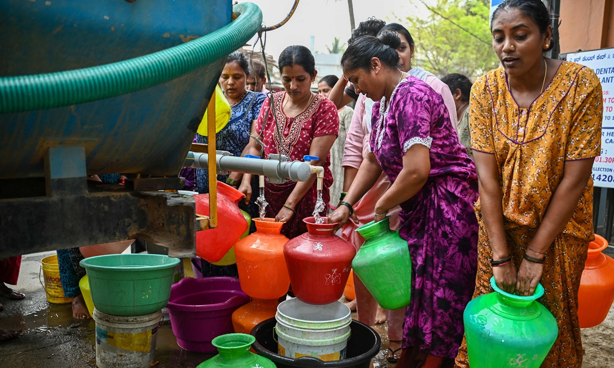 Residents collect free water from a municipal tanker amid the ongoing water crisis in Bengaluru on March 15, 2024. The “Silicon Valley” of India is facing severe water scarcity amid its worst drought in 30-40 years. Reports said more than 3,000 bore wells across the city have dried up. Photo: VCG