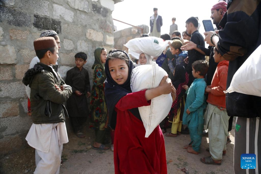 Children receive bags of gifts given by Chinese and Pakistani volunteers at a slum in Islamabad, Pakistan, on March 17, 2024. A group of a dozen Chinese and Pakistani volunteers associated with China-Pakistan Youth Exchange Community, and Beijing One Heart Sphere Charity Foundation visited two schools and delivered about 200 donation bags of gifts to children and women.(Photo: Xinhua)