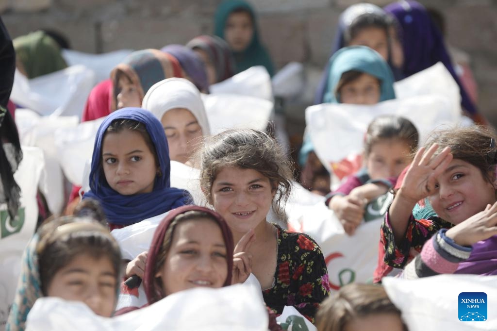 Children receive bags of gifts given by Chinese and Pakistani volunteers at a slum in Islamabad, Pakistan, on March 17, 2024. A group of a dozen Chinese and Pakistani volunteers associated with China-Pakistan Youth Exchange Community, and Beijing One Heart Sphere Charity Foundation visited two schools and delivered about 200 donation bags of gifts to children and women.(Photo: Xinhua)