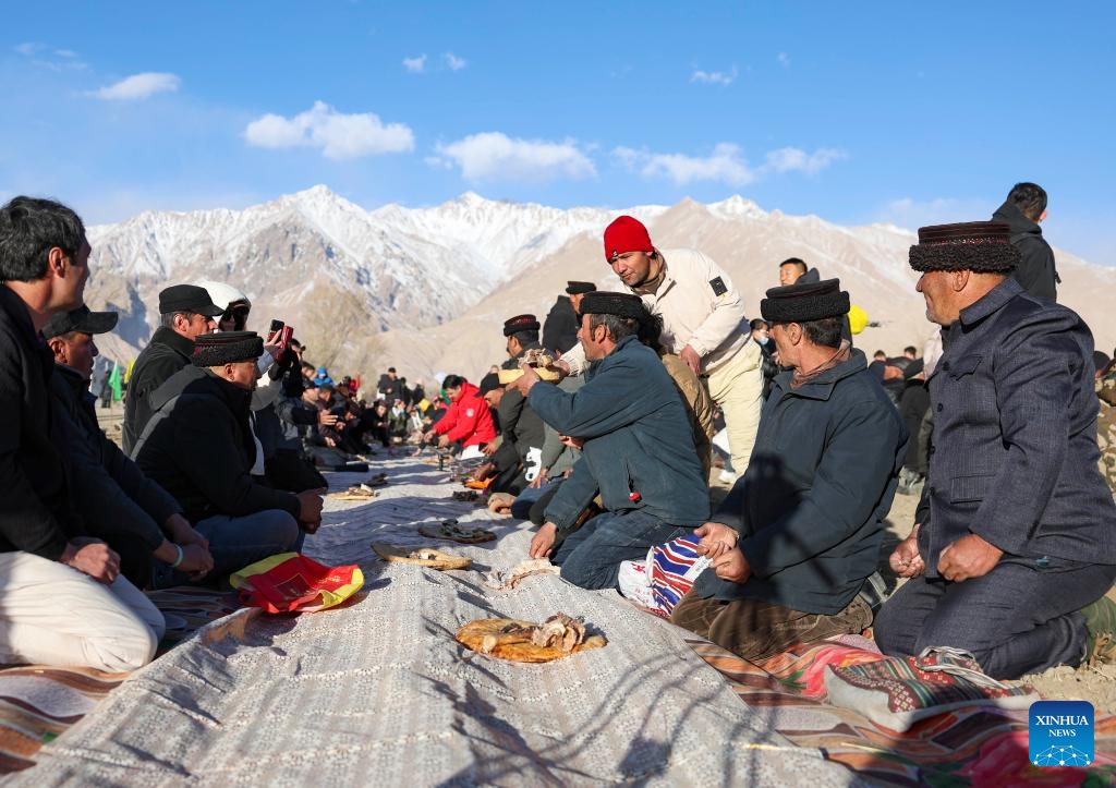 Residents share food in Warxidi village of Taxkorgan Tajik Autonomous County, northwest China's Xinjiang Uygur Autonomous Region, March 19, 2024. People in Taxkorgan Tajik Autonomous County celebrated their traditional sowing festival and drawing water festival on Tuesday. Marking the beginning of sowing seeds and drawing water, the festivals includes ceremonies to invoke good luck and good harvest. The festivals were also included in the state intangible cultural heritage list.(Photo: Xinhua)