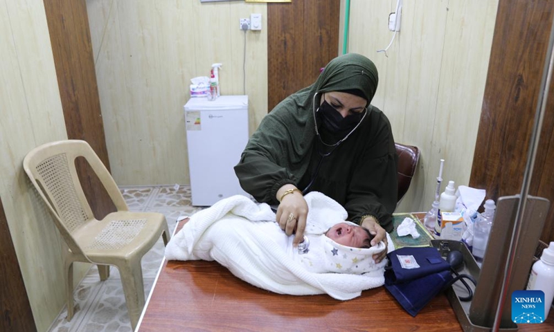 A doctor examines a child suffering from health problems in Fallujah, Iraq, March 12, 2024. Twenty years after the U.S. military offensive in the Iraqi city of Fallujah, locals are still suffering from the lasting impacts of the use of internationally banned weapons by U.S. forces.(Photo: Xinhua)