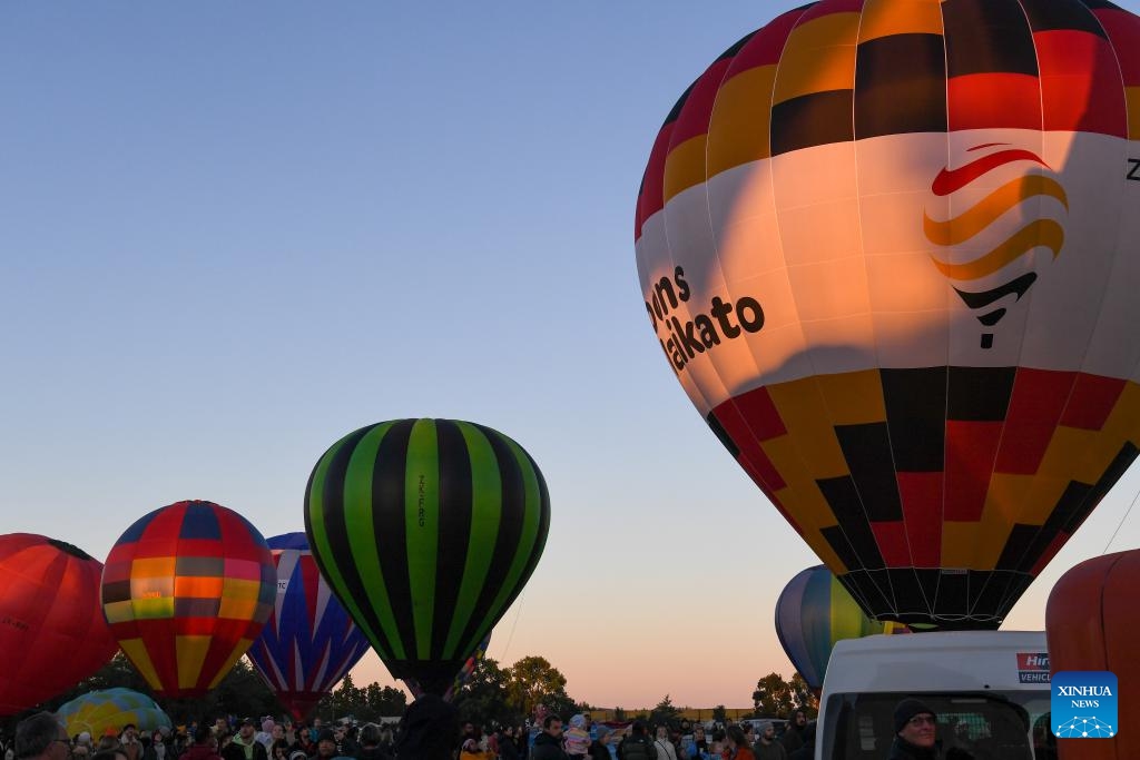 People wait for the launch of hot-air balloons during the Balloons Over Waikato Festival in Hamilton, New Zealand, March 20, 2024. The festival is held here from March 19 to 23 this year.(Photo: Xinhua)