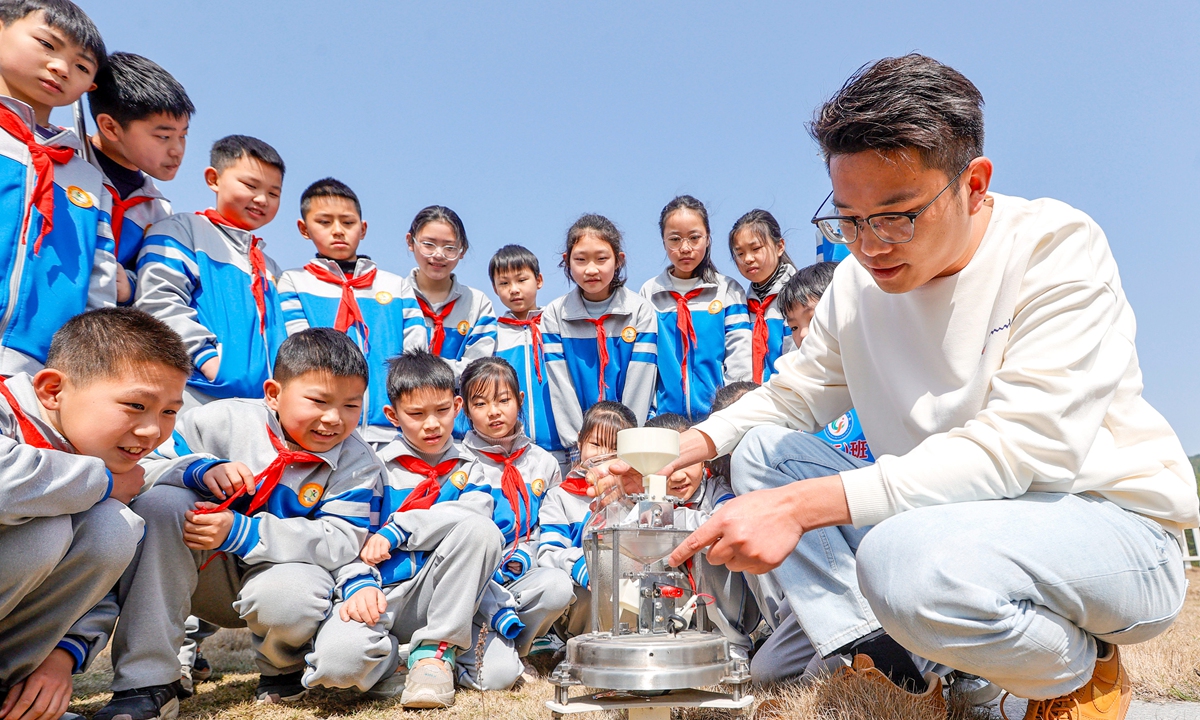 A staff member of the meteorological bureau in Xiajiang county, East China's Jiangxi Province introduces the meteorological equipment to students on March 20, 2024. Photo: VCG