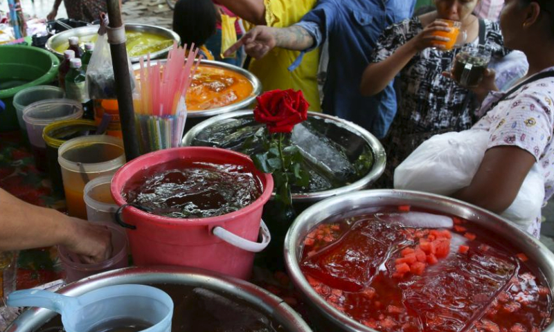 People drink juice on a hot day in Yangon, Myanmar, April 5, 2024. (Photo by Myo Kyaw Soe/Xinhua)