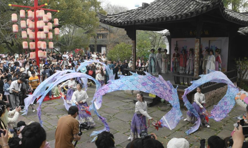 Tourists watch a performance during the Huazhao Festival celebrations in Xixi Wetland in Hangzhou, east China's Zhejiang Province, March 24, 2024. The annual Huazhao Festival featuring a series of activities, including a boat parade and a folk ritual, was celebrated in Xixi Wetland on Sunday. (Xinhua/Weng Xinyang)