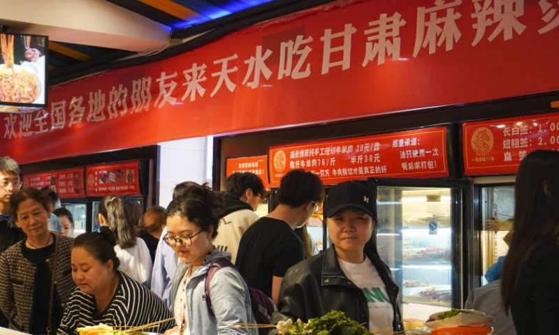 Customers are pictured in a store serving malatang in Maiji District of Tianshui City, northwest China's Gansu Province, April 3, 2024. Tianshui has garnered considerable attention in the cyber world thanks to the popularity of Tianshui's malatang, a numbing-spicy hotpot. When it comes to the real world, the city received 309,000 and 348,600 tourists on April 4 and 5, the first two day of the three-day Qingming holiday, with tourism-related revenue of 177 million yuan (about 24.47 million U.S. dollars) and 198 million yuan (about 27.37 million U.S. dollars), respectively. (Xinhua/Ma Xiping)