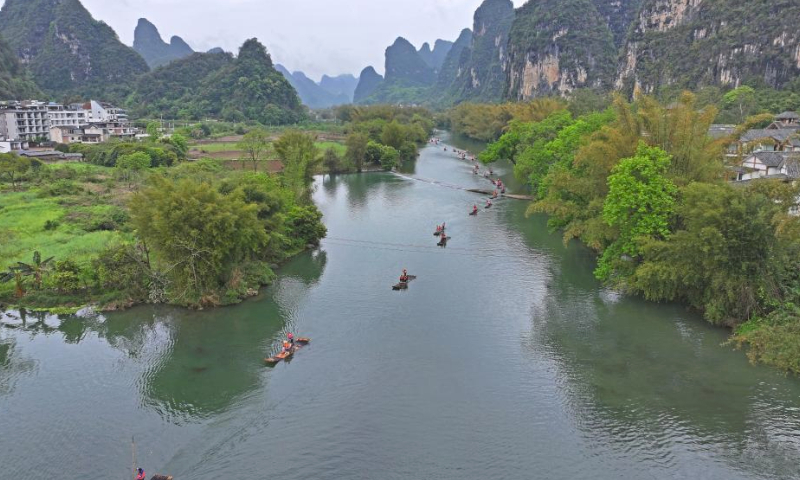 An aerial drone photo taken on March 29, 2024 shows tourists taking bamboo rafts on the Yulong River in Yangshuo County, Guilin City, south China's Guangxi Zhuang Autonomous Region. (Xinhua/Zhou Hua)