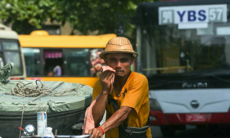 A man wipes sweat from his face during a hot day in Yangon, Myanmar, April 5, 2024. (Photo by Myo Kyaw Soe/Xinhua)