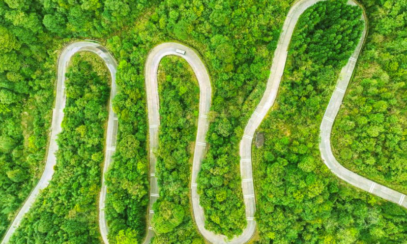 An aerial drone photo taken on March 29, 2024 shows a car running on a winding road in Laibin City, south China's Guangxi Zhuang Autonomous Region. (Photo by Gao Rujin/Xinhua)