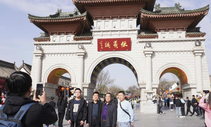 Tourists pose for photos at Fuxi Temple scenic area in Qinzhou District of Tianshui City, northwest China's Gansu Province, April 4, 2024. Tianshui has garnered considerable attention in the cyber world thanks to the popularity of Tianshui's malatang, a numbing-spicy hotpot. When it comes to the real world, the city received 309,000 and 348,600 tourists on April 4 and 5, the first two day of the three-day Qingming holiday, with tourism-related revenue of 177 million yuan (about 24.47 million U.S. dollars) and 198 million yuan (about 27.37 million U.S. dollars), respectively. (Xinhua/Ma Xiping)