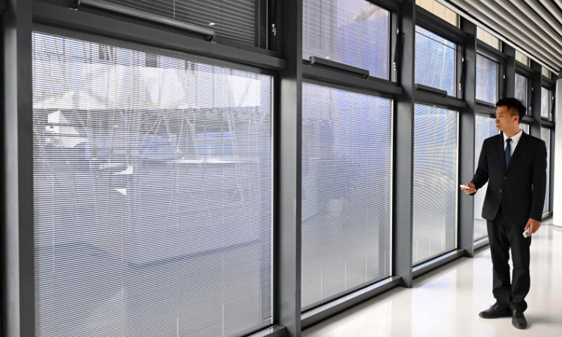 A staff member shows the coated glass with thermal insulation and shading effects at the Xiong'an pilot free trade zone communication and exhibition center in Xiong'an New Area, north China's Hebei Province, March 28, 2024. In April 2017, China announced a plan to establish the Xiong'an New Area, which spans the Rongcheng, Anxin and Xiongxian counties, as well as some adjacent areas in north China's Hebei Province.

The new area aims to relieve Beijing of non-essential functions related to its status as the nation's capital, while also advancing the coordinated development of the Beijing-Tianjin-Hebei region.

The country has also vowed to build Xiong'an, dubbed the city of the future, into an innovative, green, smart and world-class city with blue skies, fresh air and clean water, in line with the country's high-quality development path. (Xinhua/Mu Yu)