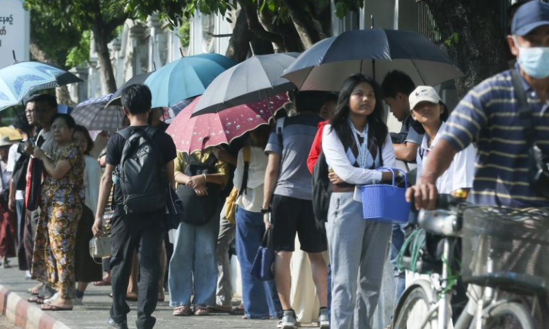 People shade themselves from sunshine with umbrellas on a hot day in Yangon, Myanmar, April 5, 2024. (Photo by Myo Kyaw Soe/Xinhua)