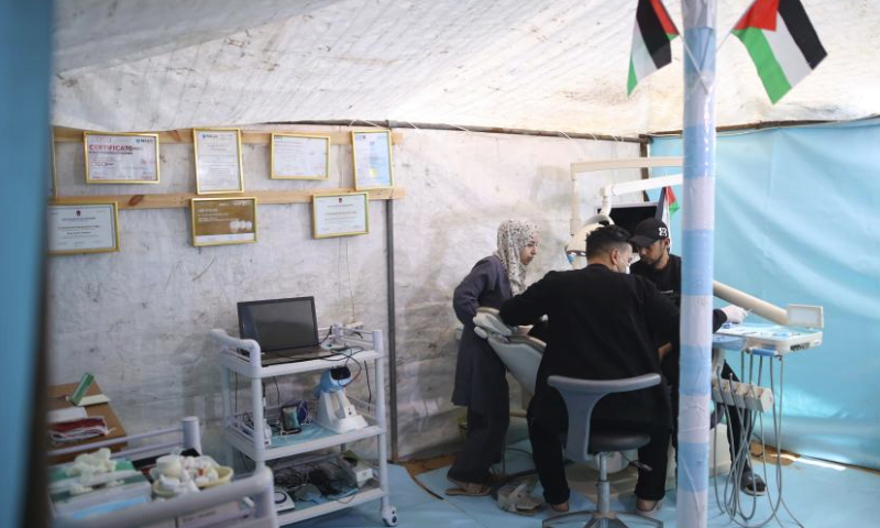 A dentist treats a patient at a temporary clinic in the Nuseirat refugee camp, central Gaza Strip, March 30, 2024. (Xinhua)
