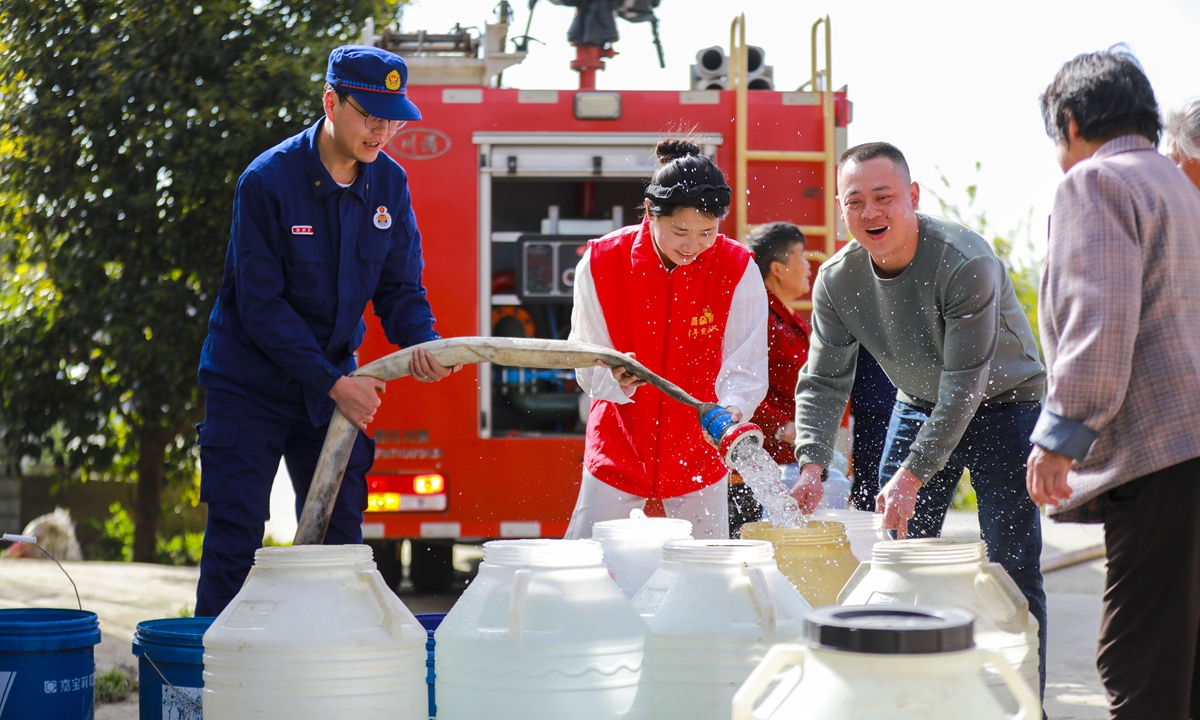 Local firefighters and Party member volunteers deliver water to villagers in Yuduo town in Bijie city, Southwest China's Guizhou Province, on March 25, 2024. Recent high temperatures have caused a shortage of drinking water and irrigation water for some villagers, so the town provides door-to-door water delivery services to ensure the water supply for people's daily life and ag-ricultural production. Photo: VCG