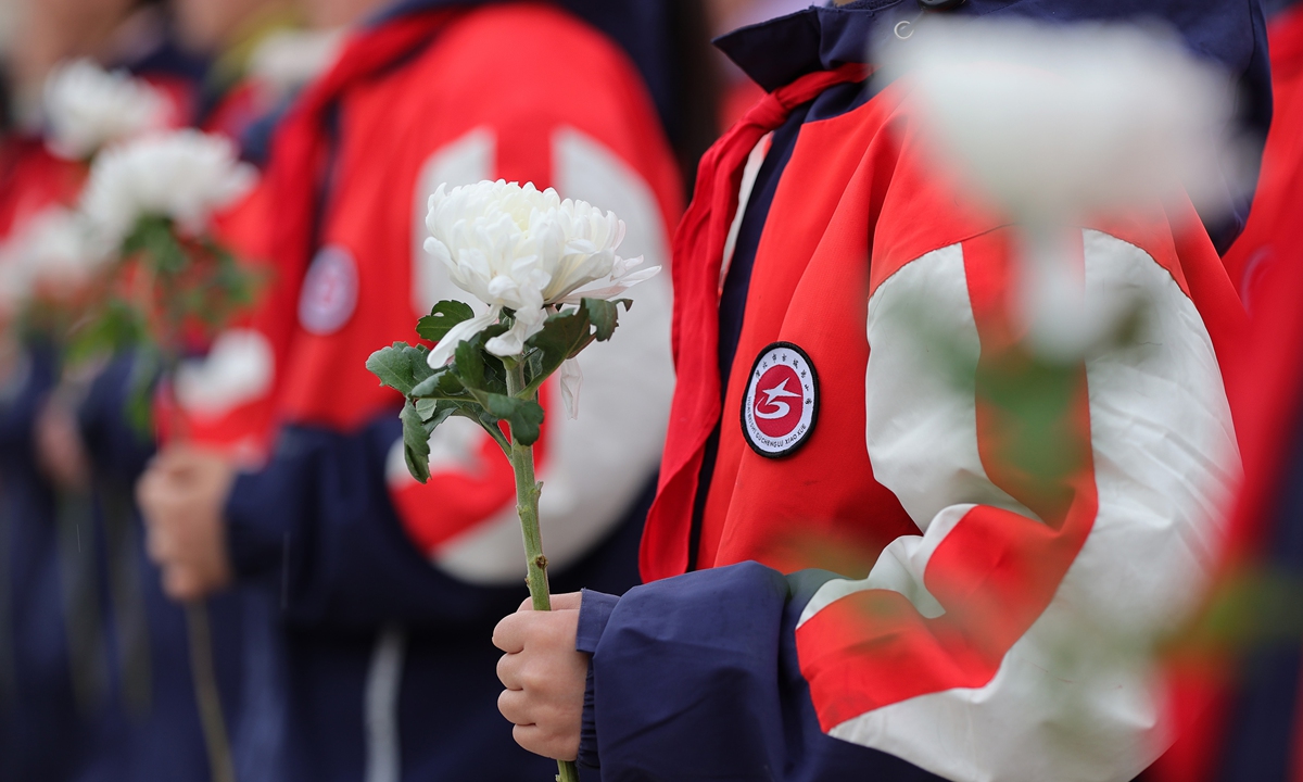 Elementary school students in Huaibei, East China's Anhui Province lay flowers on the tombstones of martyrs at the cemetery of martyrs on March 27, 2024. Photo: VCG