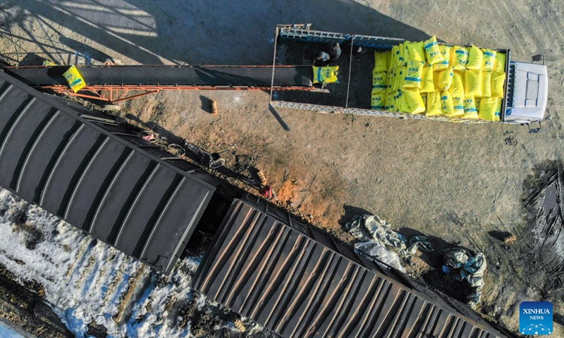 An aerial drone photo taken on March 14, 2024 shows workers unloading bags of fertilizer near a railway line for agricultural supplies in Shuangyashan City, northeast China's Heilongjiang Province. China's major grain production province Heilongjiang, known as the country's grain barn, is conducting a wide range of activities to ensure a robust foundation for spring farming. (Xinhua/Wang Song)