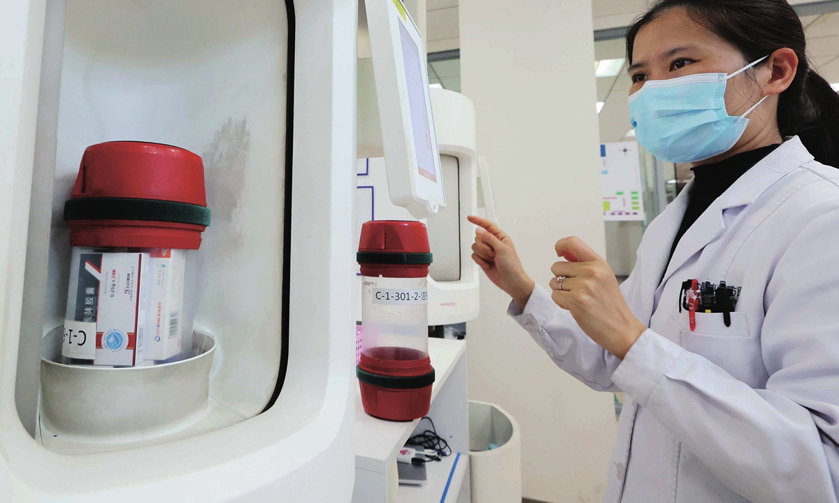 A staffer distributes medicine through an automatic dispensing machine in a smart pharmacy in a hospital in Hefei, East China's Anhui Province on April 7, 2024. The pneumatic logistics system can bring medicine directly to the pharmacist on a designated floor, shortening the time for patients to pick up their medicine. Photo: VCG