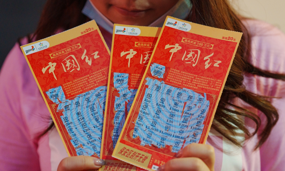 A customer shows off three used scratch tickets. Photo: VCG